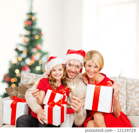 smiling family holding gift boxes and sparkles 12139729