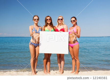 group of smiling women with blank board on beach 12140381