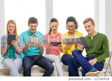 smiling students with tablet pc computer 12140416