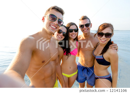 group of smiling friends making selfie on beach group of smiling friends making selfie on beach 12141106