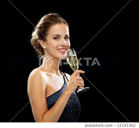 smiling woman holding glass of sparkling wine smiling woman holding glass of sparkling wine 12141302