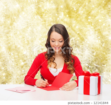 smiling woman with gift box writing letter 12141844