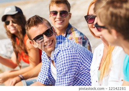 close up of smiling friends sitting on city street 12142281