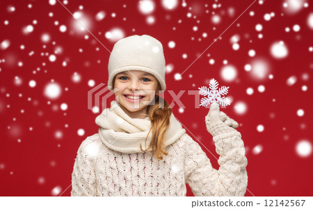 smiling girl in winter clothes with big snowflake 12142567