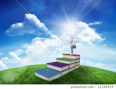 Composite image of attractive student holding books and her bag 12144414