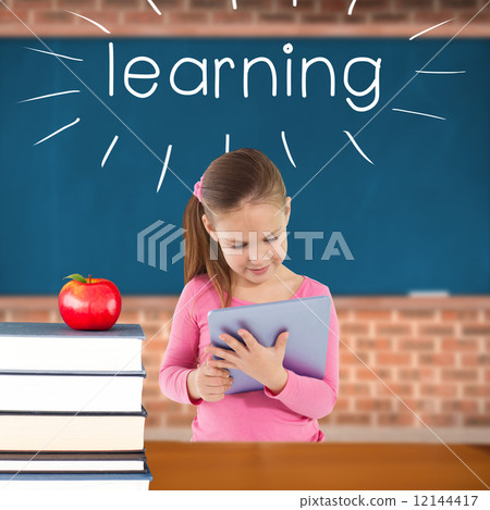 Learning against red apple on pile of books in classroom 12144417