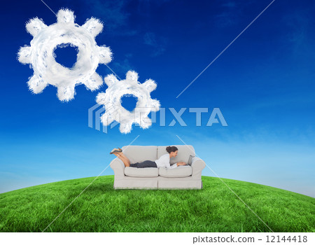 Composite image of business woman lying on couch 12144418