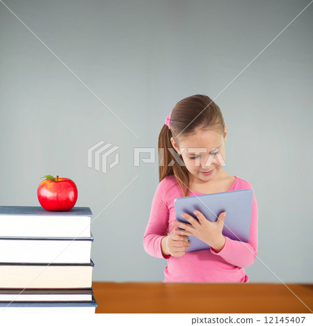 Composite image of cute girl using tablet 12145407