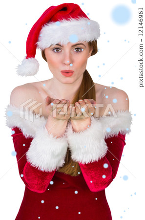 Composite image of pretty girl in santa costume blowing at camer 12146961