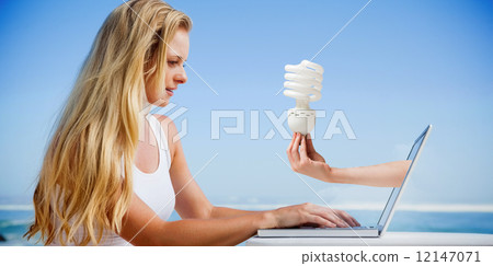 Composite image of pretty blonde using her laptop at the beach Composite image of pretty blonde using her laptop at the beach 12147071