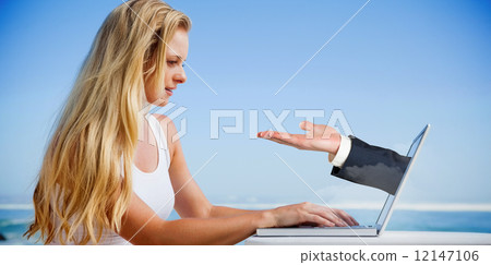 Composite image of pretty blonde using her laptop at the beach 12147106