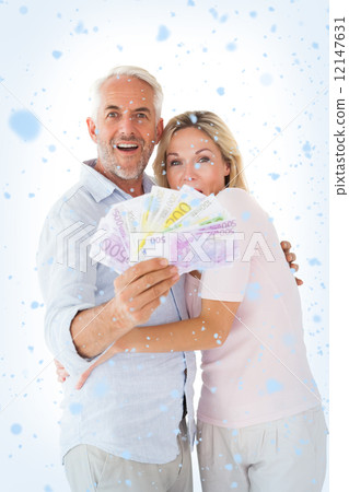 Composite image of happy couple flashing their cash Composite image of happy couple flashing their cash 12147631