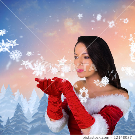 Composite image of pretty girl in santa outfit blowing Composite image of pretty girl in santa outfit blowing 12148087