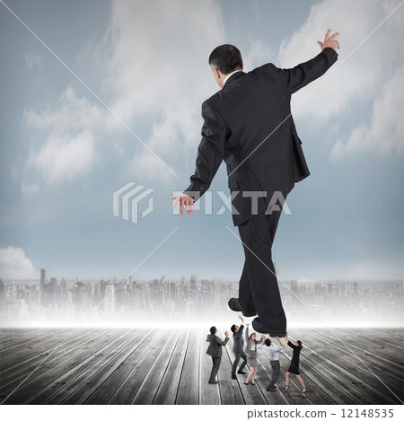 Composite image of business team supporting boss Composite image of business team supporting boss 12148535