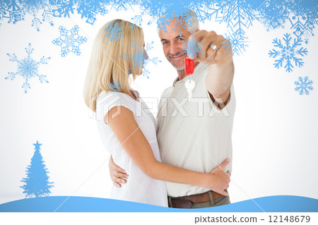 Composite image of happy couple showing their new house key Composite image of happy couple showing their new house key 12148679