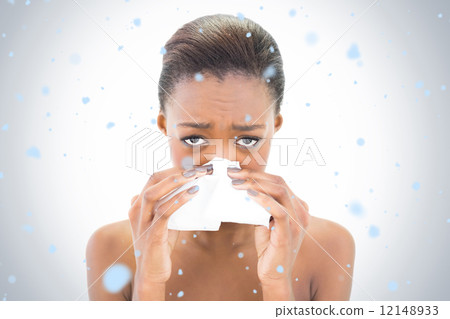 Composite image of worried natural beauty blowing her nose Composite image of worried natural beauty blowing her nose 12148933