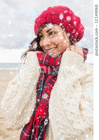 Composite image of cute smiling woman in warm clothing looking a 12149068