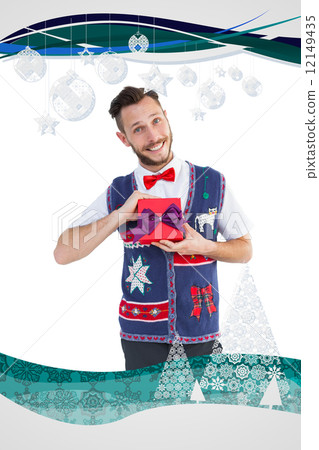 Composite image of geeky hipster offering christmas gift Composite image of geeky hipster offering christmas gift 12149435