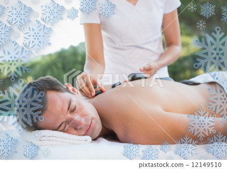 Handsome man getting a hot stone massage poolside Handsome man getting a hot stone massage poolside 12149510