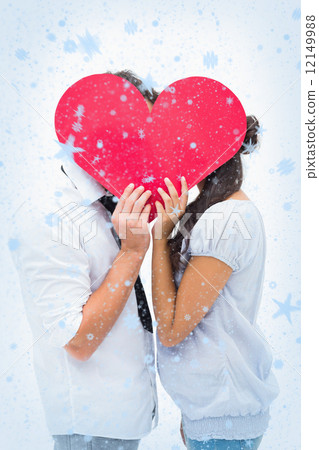 Couple covering their kiss with a heart 12149988