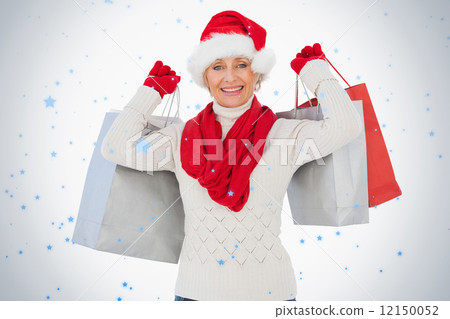Festive woman smiling at camera holding shopping bags 12150052