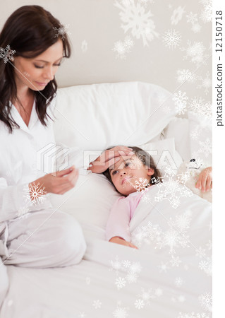 Mother checking on her daughters temperature Mother checking on her daughters temperature 12150718