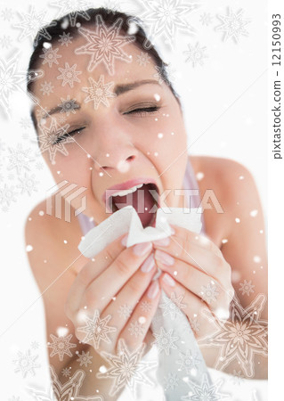 Woman sneezing into a tissue Woman sneezing into a tissue 12150993