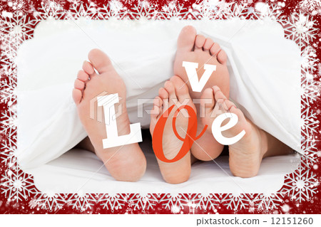 Composite image of pair of feet under duvet with love text Composite image of pair of feet under duvet with love text 12151260