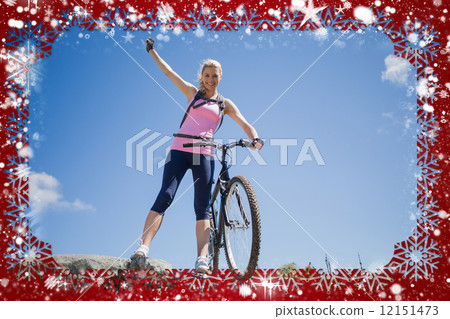 Fit pretty cyclist on a rocky terrain smiling at camera 12151473