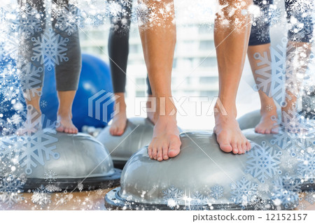 Low section of fit people standing on exercise equipment 12152157
