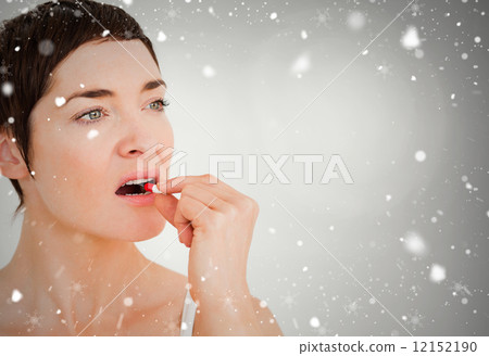 Composite image of close up of a woman taking a pill 12152190