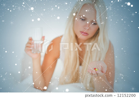 Composite image of blonde woman looking at a pill Composite image of blonde woman looking at a pill 12152200