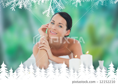 Beautiful brunette relaxing on massage table smiling at camera Beautiful brunette relaxing on massage table smiling at camera 12152210