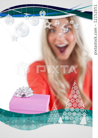 Composite image of astonished woman holding a gift Composite image of astonished woman holding a gift 12152851