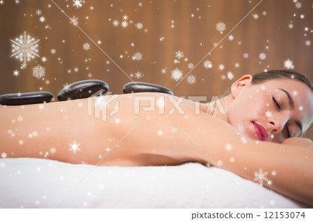 Beautiful woman receiving stone massage at health farm 12153074