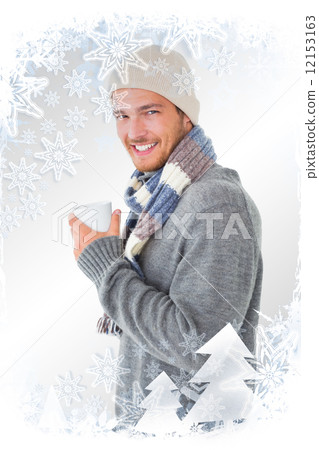 Composite image of handsome man in winter fashion holding mug 12153163