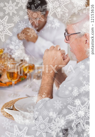 Family saying grace before eating 12153616