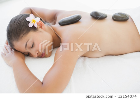 Beautiful brunette enjoying a hot stone massage 12154074