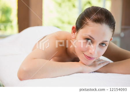 Beautiful woman lying on massage table at spa center 12154093