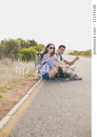 Couple hitchhiking on countryside road Couple hitchhiking on countryside road 12154186