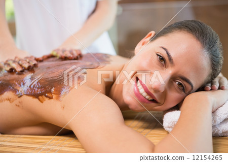 Attractive woman receiving chocolate back mask at spa center 12154265