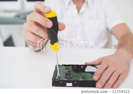 Computer engineer working on broken cpu with screwdriver Computer engineer working on broken cpu with screwdriver 12154522