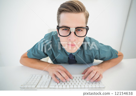 Casual businessman typing at his desk Casual businessman typing at his desk 12154638