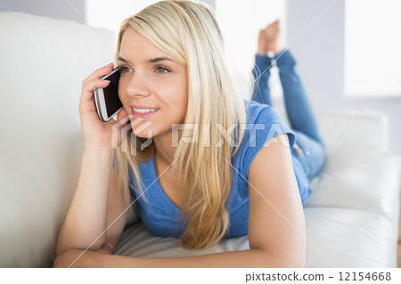 Relaxed beautiful woman using mobile phone in living room Relaxed beautiful woman using mobile phone in living room 12154668