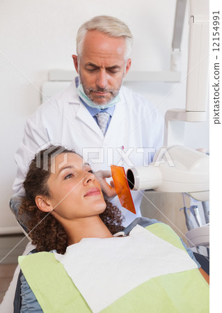 Dentist taking an xray of patients mouth 12154991