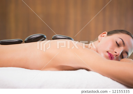 Beautiful woman receiving stone massage at health farm 12155335