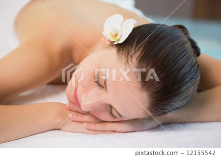 Beautiful woman lying on massage table at spa center 12155542