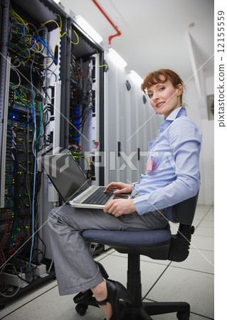 Happy technician sitting on swivel chair using laptop to diagnos Happy technician sitting on swivel chair using laptop to diagnos 12155559