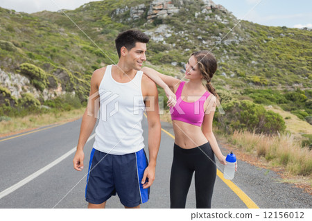 Portrait of a fit couple standing on road 12156012