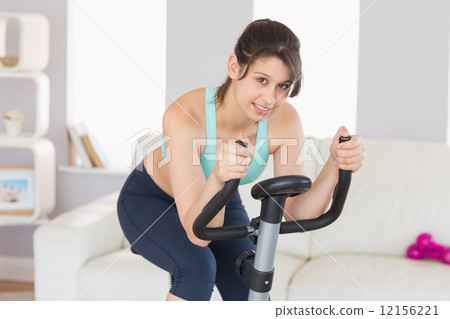 Fit brunette working out on exercise bike Fit brunette working out on exercise bike 12156221